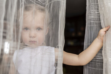 Girl staring behind translucent curtains - FSIF00565