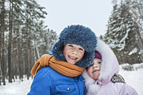 Ein fröhliches Geschwisterpaar in warmer Winterkleidung im Freien im Winter - FSIF00605