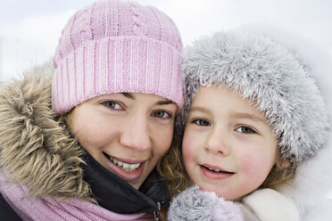 Eine fröhliche Mutter und ihre Tochter in warmer Kleidung im Freien im Winter - FSIF00608