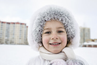 Ein fröhliches junges Mädchen trägt warme Kleidung im Freien im Winter - FSIF00611