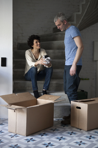 Ein altersgemischtes Paar packt Umzugskartons, lizenzfreies Stockfoto