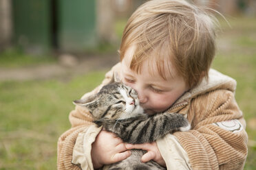 Kleines Mädchen hält Katze und küsst sie - FSIF00674