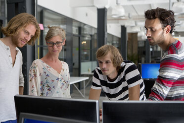 Bürokollegen schauen im Büro auf den Computer - FSIF00701