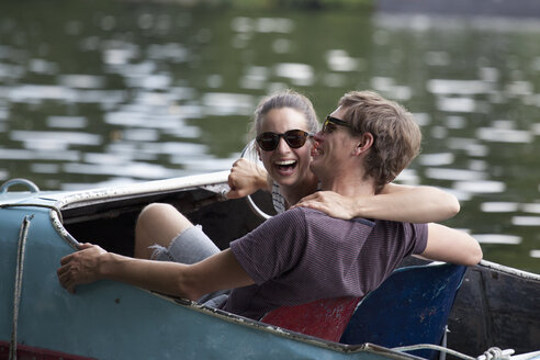 Junges Paar fährt lachend auf einem Tretboot - FSIF00708