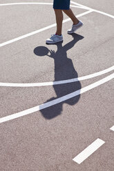 Man playing basketball, low section - FSIF00719