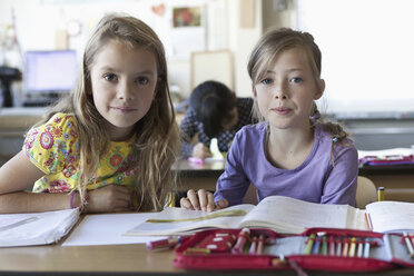 Drei Mädchen mit Büchern im Klassenzimmer - FSIF00739