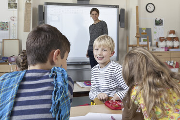 Boy in classroom talking with students - FSIF00743