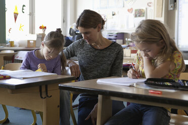 Lehrerin unterrichtet Mädchen im Klassenzimmer - FSIF00746