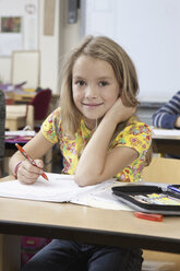 Girl with book in classroom, portrait - FSIF00748