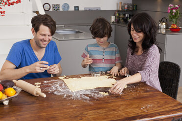 Family making Christmas cookies at dining table - FSIF00802
