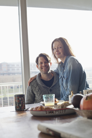 Ehepaar beim Frühstück am Esstisch, Porträt, lizenzfreies Stockfoto