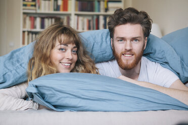Portrait of happy young couple lying in bed - FSIF00851