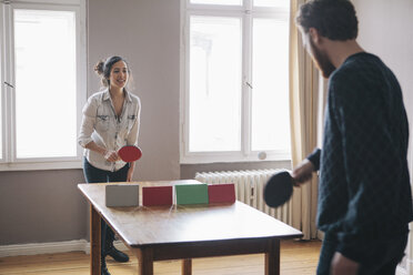 Junge Frau spielt Tischtennis mit Mann zu Hause - FSIF00874