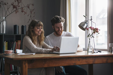 Junges Paar benutzt Laptop am Tisch am Fenster - FSIF00875