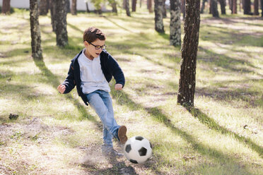 Voller Länge von glücklichen Jungen spielen Fußball im Wald - FSIF00889