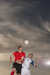 Männliche Fußballspieler köpfen den Ball gegen den Himmel - FSIF00911