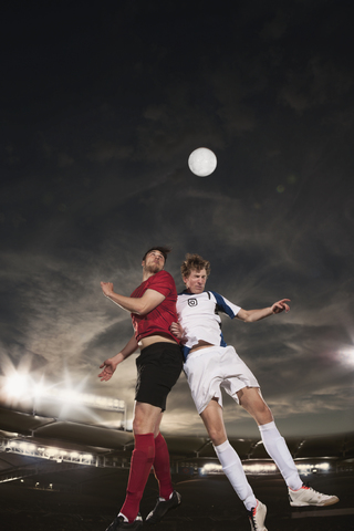 Männliche Fußballspieler köpfen den Ball während des Spiels, lizenzfreies Stockfoto
