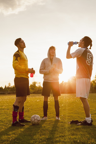 Full length of young soccer players standing on field stock photo