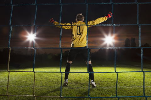 Volle Länge Rückansicht des Torwarts verteidigt Fußballnetz auf dem Feld, lizenzfreies Stockfoto