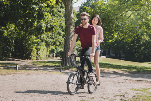 Junges Paar in voller Länge beim Fahrradfahren im Park - FSIF00963