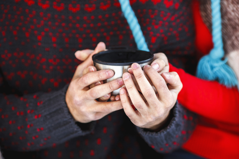 Mittelteil eines jungen Paares mit Kaffeetasse im Winter, lizenzfreies Stockfoto