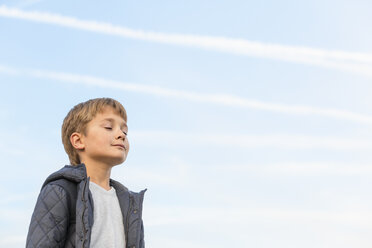 Niedriger Blickwinkel des Jungen mit geschlossenen Augen gegen den Himmel - FSIF00994