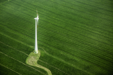 Blick von oben auf eine Windkraftanlage in einer grünen Landschaft, lizenzfreies Stockfoto