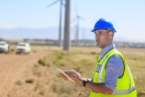 Engineer using tablet on a wind farm stock photo