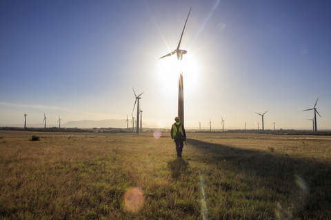 Ingenieur auf einem Windpark bei Sonnenuntergang, lizenzfreies Stockfoto