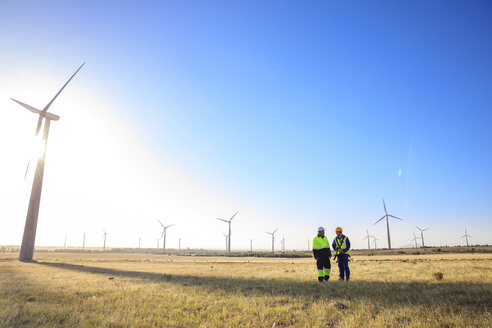 Two engineers discussing on a wind farm - ZEF14978