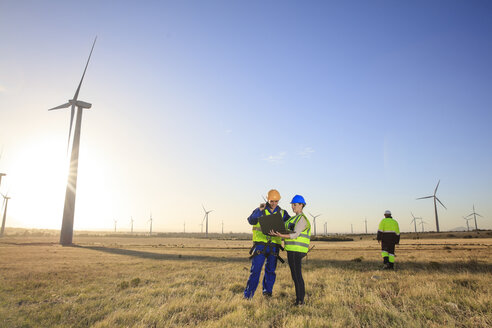 Drei Ingenieure mit Laptop in einem Windpark - ZEF14981