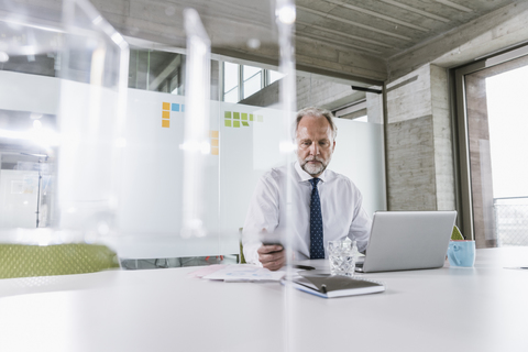 Mature businessman working at desk in office stock photo