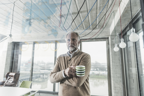 Casual mature businessman looking at data at glass pane in office stock photo