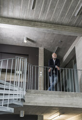 Mature businessman standing in staircase - UUF12782