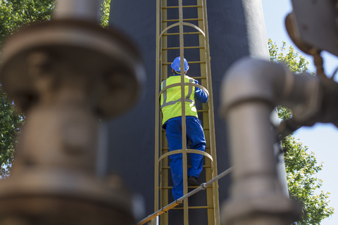 Südafrika, Kapstadt, Bauarbeiter klettert Leiter hoch, lizenzfreies Stockfoto
