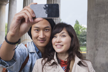 Smiling man taking selfie with young female friend - FSIF01087