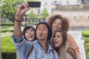 Young man making face while taking selfie with female friends, Berlin, Germany - FSIF01090