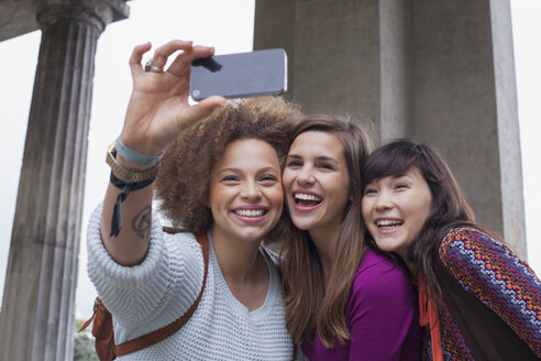 Niedriger Winkel Blick auf lächelnde junge weibliche Freunde nehmen Selfie - FSIF01092