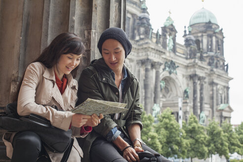 Blick von unten auf junge Freunde, die eine Karte im Alten Museum vor dem Berliner Dom lesen, Deutschland - FSIF01098