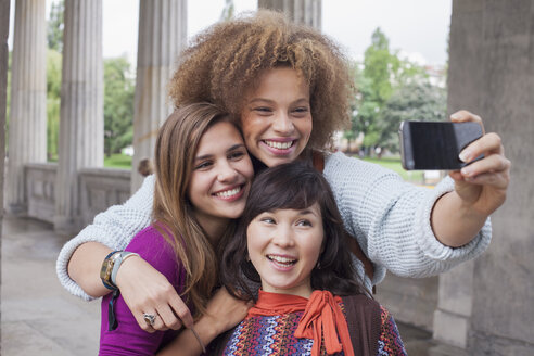 Lächelnde junge Frau macht Selfie mit Freundinnen - FSIF01100