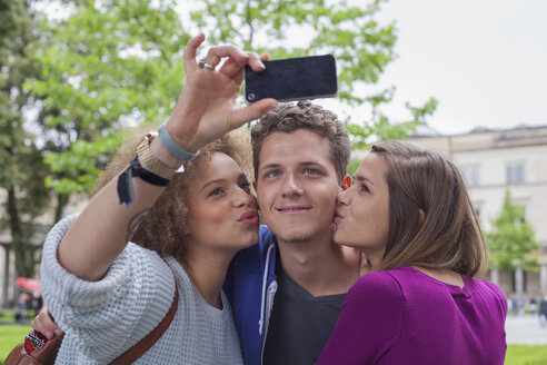 Frau macht Selfie mit Freundin und küsst jungen Mann - FSIF01103