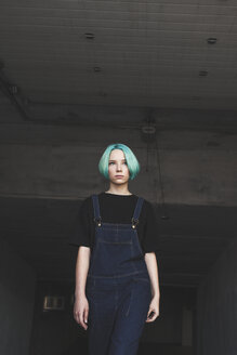 Low angle view of teenage girl standing in basement - FSIF01118