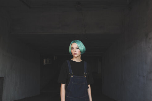 Portrait of teenage girl standing in basement - FSIF01120