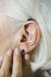 Cropped image of senior woman wearing hearing aid - FSIF01135