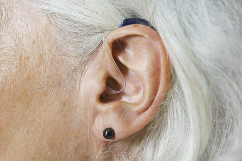 Nahaufnahme einer Frau mit grauem Haar und Hörgerät - FSIF01139