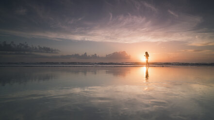 Silhouette woman at sea shore against cloudy sky during sunset, Daytona, Florida, USA - FSIF01157