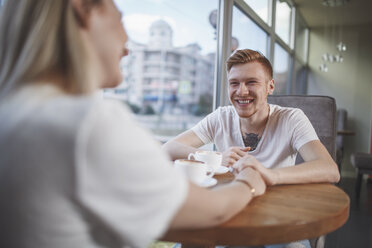 Lächelnder Mann sitzt mit Freundin im Restaurant - FSIF01167