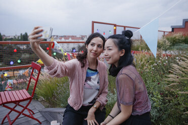Lächelnde Frauen nehmen Selfie mit Smartphone auf Terrasse - FSIF01182