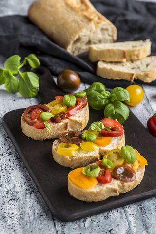 Bruschetta, ciabatta with multi-coloured tomatoes and basil stock photo