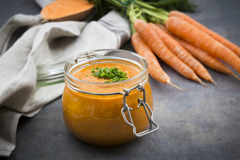 Glass of sweet potato carrot soup garnished with chives - LVF06697